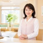51歳の女性医療事務がクリニック受付で前向きな表情を見せる転職成功イメージ